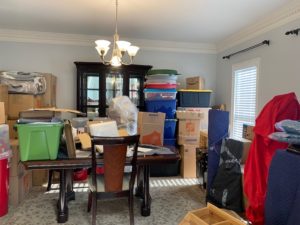 Dining room filled with countless totes and moving boxes